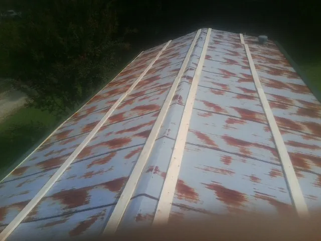 Rusted metal roof panels with new wood purlins before replacement — Storm Damage Roof Repair in Spencerville by Roofing Brothers